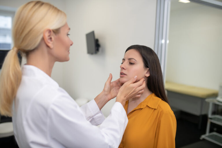 Un docteur ausculte une patiente qui a un bouton sur le palais qui revient tout le temps
