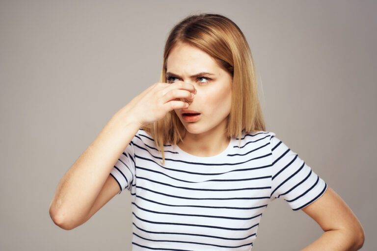 Une femme en train de toucher son nez