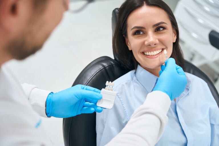 Dentiste auscultant les dents d'une patiente en vue d'une extraction de la couronne dentaire