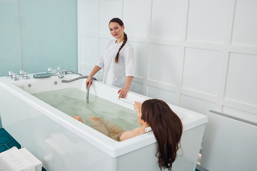 Une professionnelle effectuant un bain dérivatif sur une cliente montrant l'efficacité du bain dérivatif sur la graisse abdominale