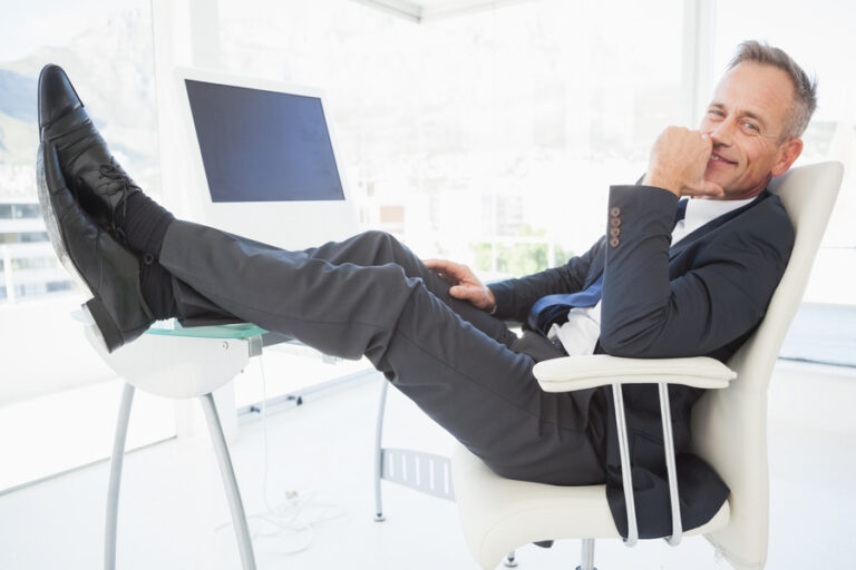 Un grand homme qui se relaxe au bureau en montant ses pieds sur la table et ne rien faire