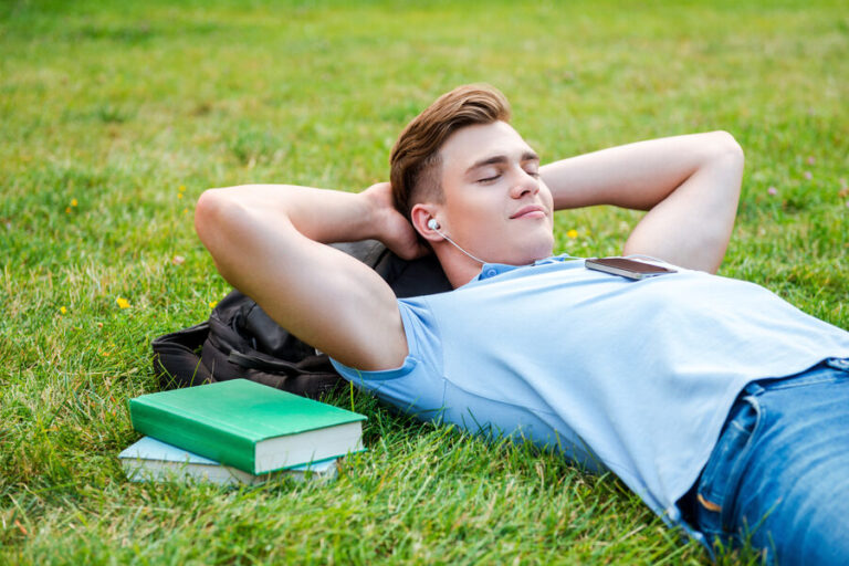 Un étudiant qui prend une pause en s'allongeant et en écoutant de la musique pour se relaxer avant son examen
