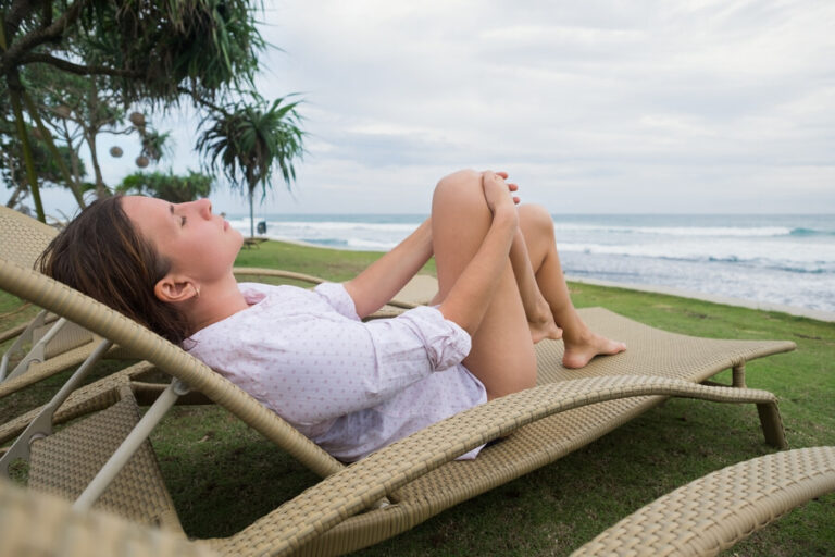 Une femme qui se repose sur une chaise au bord de la mer pour relaxer son cerveau