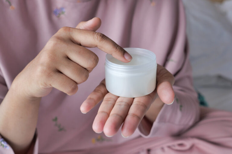 Une femme montrant la meilleure crème cosmétique pour traiter le l'eczéma