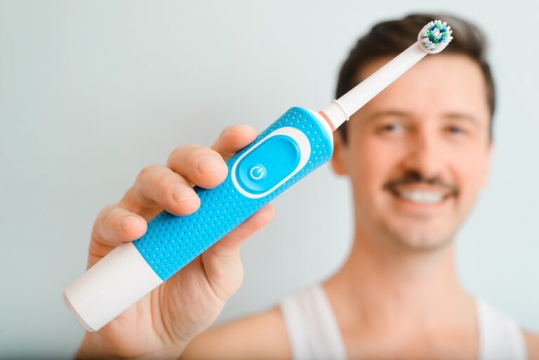 Une personne tient une brosse à dents électrique en position pour nettoyer ses dents