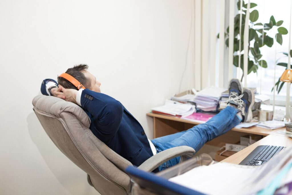 Employé en position détendue, bras croisés sur le bureau, rechargeant son énergie pendant une pause sommeil rapide