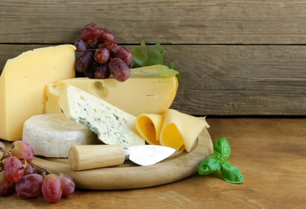Des morceaux de fromages sains avec des raisins et un couteau