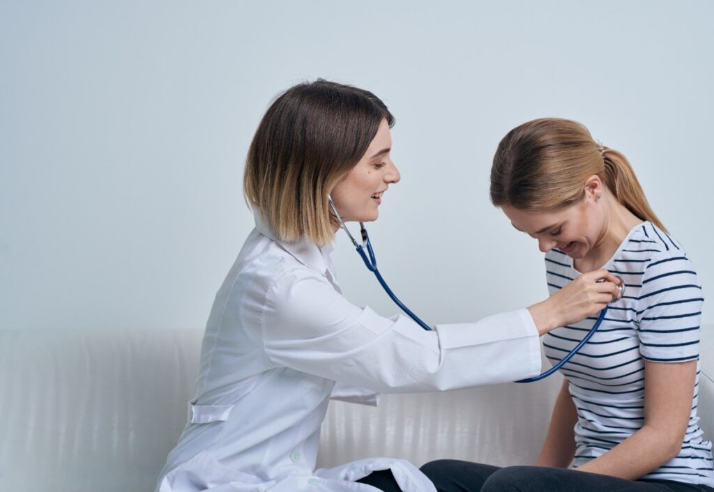 Un médecin qui met un stéthoscope à une patiente pour un bilan de santé