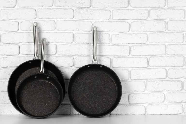 Des poêles noires sur un mur en brique dans la cuisine