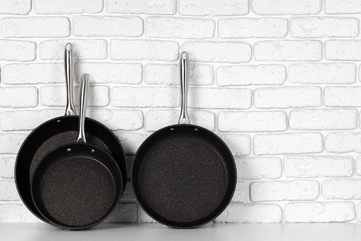 Des poêles noires sur un mur en brique dans la cuisine