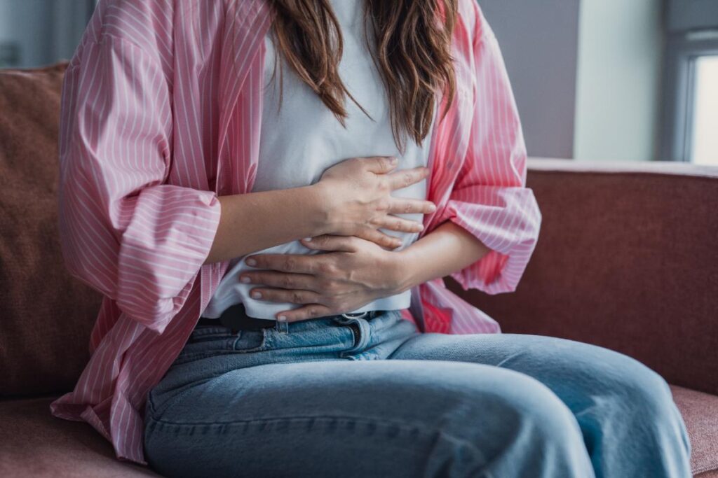 Une femme assise tenant son ventre