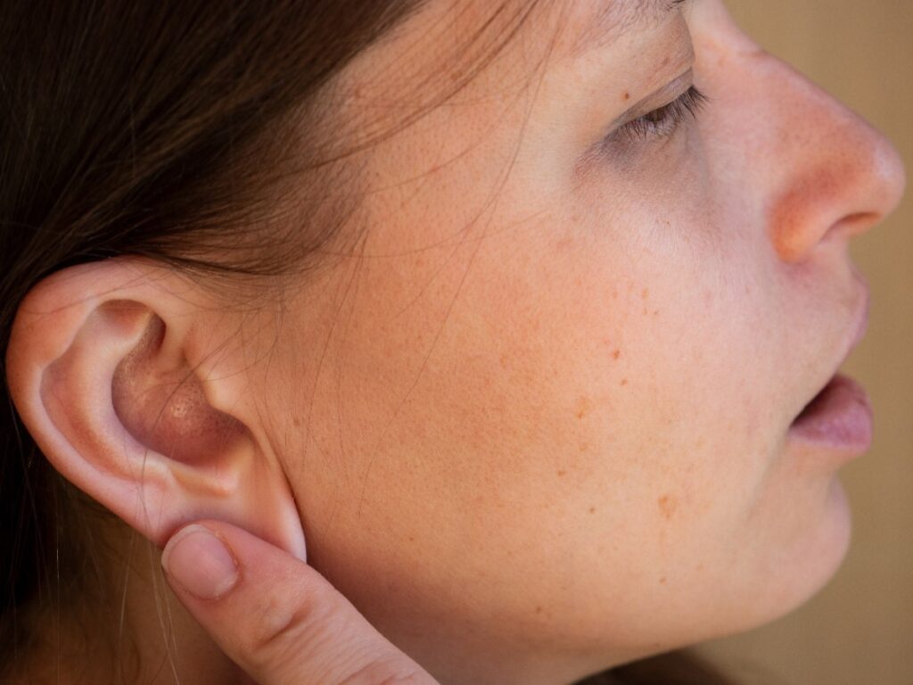 Une femme ayant une boule dans le lobe de son oreille