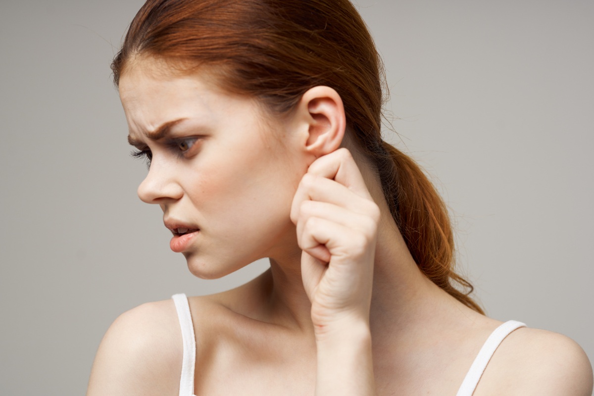 Une femme soucieuse en touchant son oreille