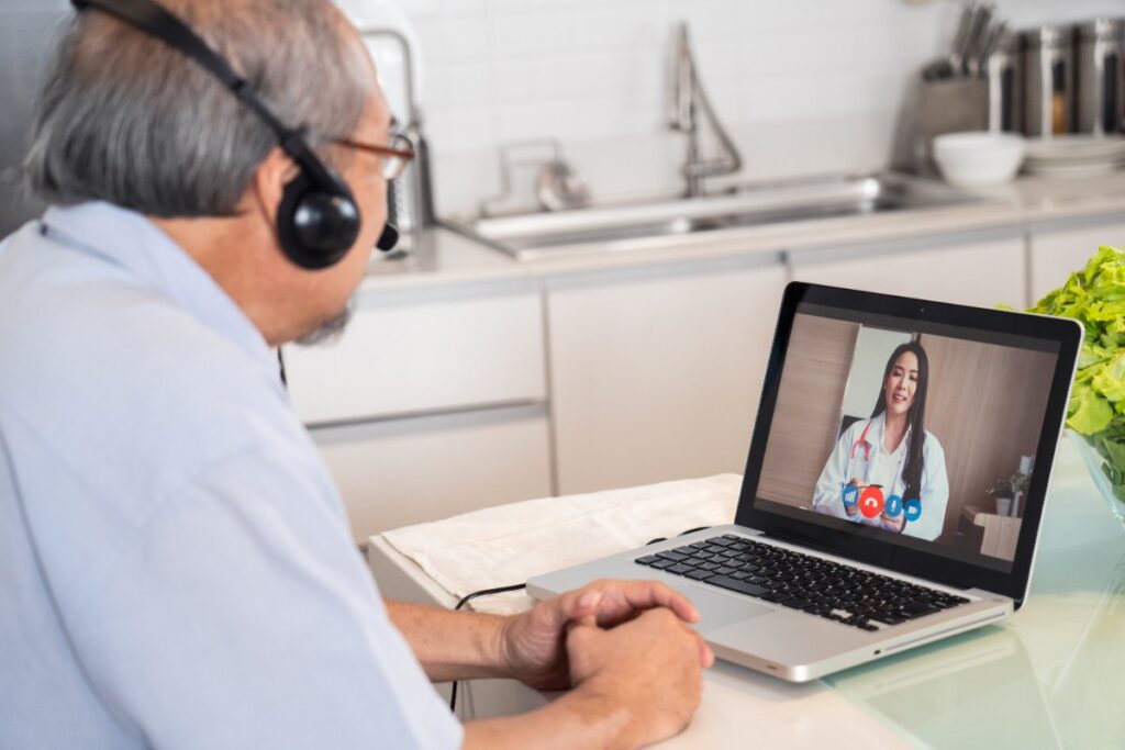 Un homme âgée faisant un appel de télémédecine avec un ordinateur portable