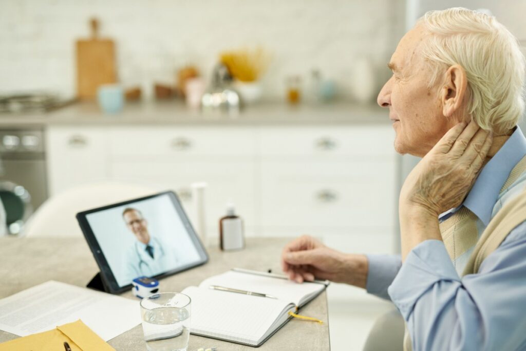 Un homme en téléconsultation en utilisant une tablette sur la table