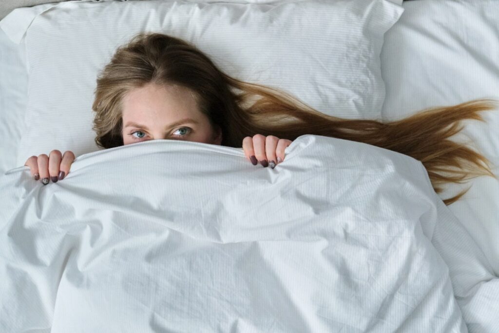 Une femme allongée sur le lit sous une couette