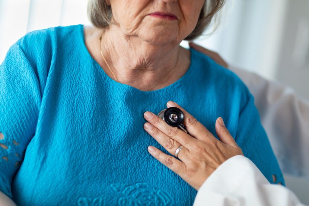 Un médecin vérifiant le coeur d'une femme âgée avec un stéthoscope