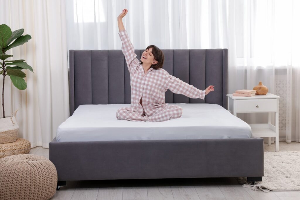 Une femme s'étirant sur le lit dans sa chambre