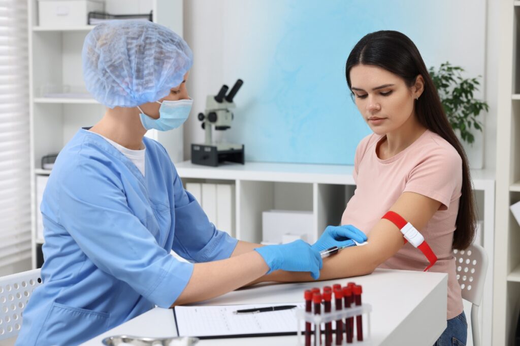 Une infirmière faisant une prise de sang à une jeune femme