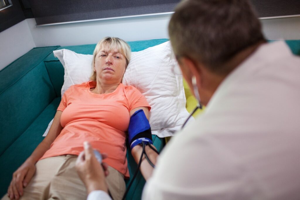 Un médecin mesurant la tension artérielle d'une personne âgée