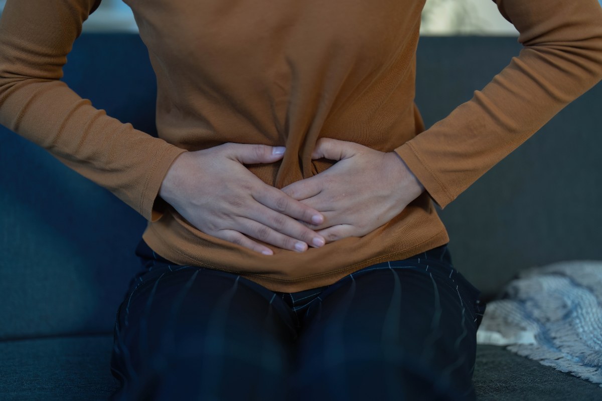 Une personne qui ressente de l'incofort gastrique et serrant son ventre